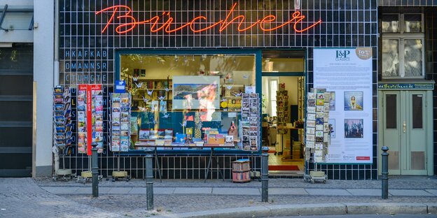 Buchhandlung in Berlin-Schöneberg: Mit Leuchtschrift steht das Wort Bücher über einen liebevoll eingerichteten Geschäft