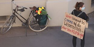 Demonstrantin mit Schild: "Warum hören wir bei Corona auf die Wissenschaft, bei Corona nicht?"