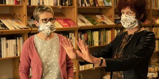 Menschen mit Atemschutzmasken in einer Buchhandlung