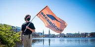 Demonstrant mit Seebrücke-fahne an der Alster in Hamburg