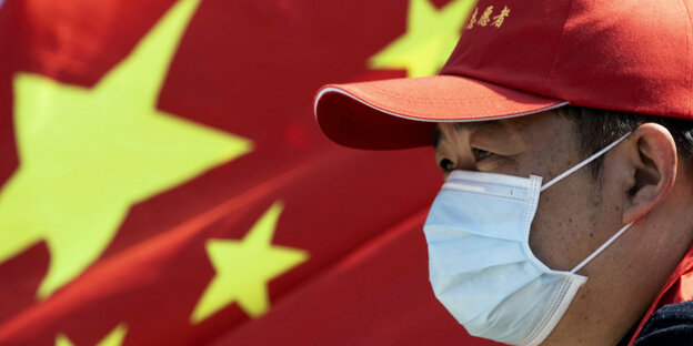 Chinesische Flagge und Mann mit Maske