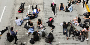 Studierende sitzen und liegen vor der Universidad Nacional in Bogotá aus.