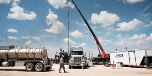 Frackingbaustelle mit Kran und Tanker in den USA.