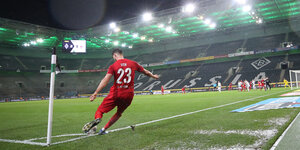 Ein Spieler tritt in einem leeren Stadion eine Ecke.