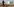 Ein Arbeiter auf einem Rad vor einem Öltank.