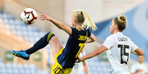 Zwei Fussballerinen von Schweden und Deutschland im Zweikampf. Zwei Fussballerinen von Schweden und Deutschland im Zweikampf.