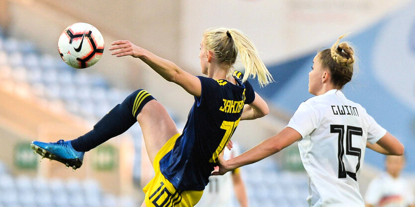 Zwei Fussballerinen von Schweden und Deutschland im Zweikampf.