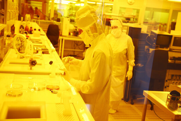 Eine Mitarbeiterin fertigt in einem Reinraumlabor unter Gelblicht Sensoren für Beatmungsgeräte Eine Mitarbeiterin fertigt in einem Reinraumlabor unter Gelblicht Sensoren für Beatmungsgeräte