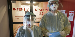 Zwei Menschen in Schutzkleidung in einem Klinikum.