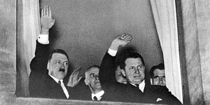 Adolf Hitler winkt aus einem Fenster.