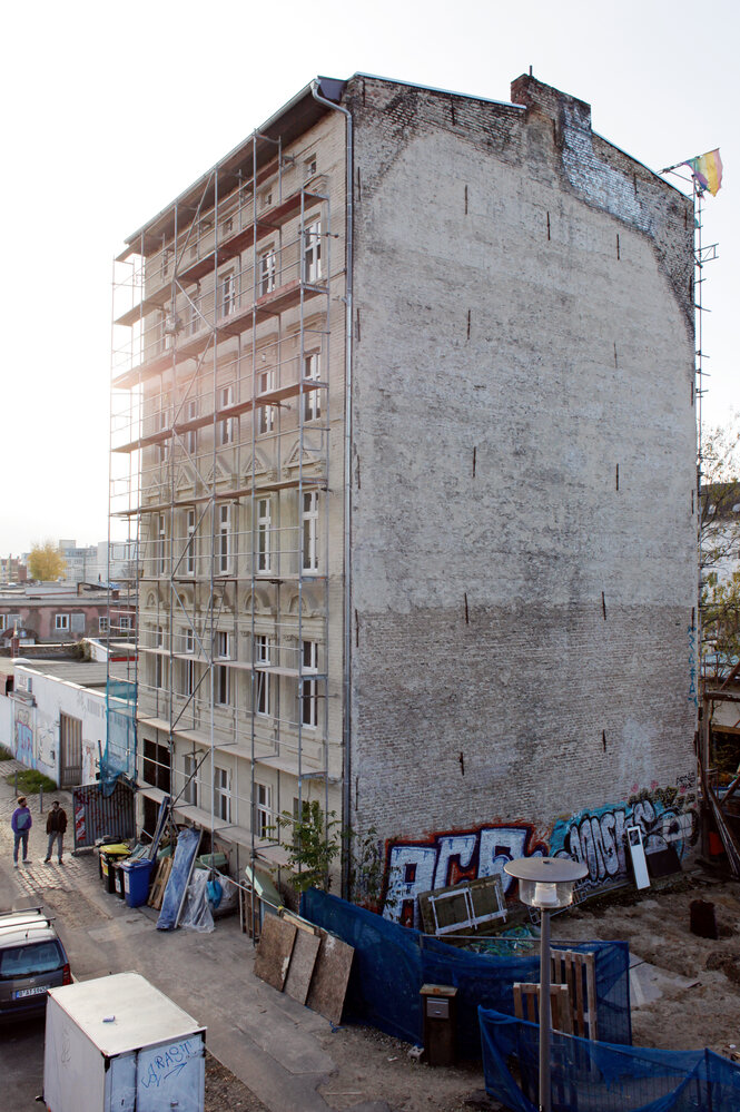 Ein alleinstehendes Haus im Gründerzeitstil, die Fassade ist eingerüstet, die andere Wand eine Brandwand