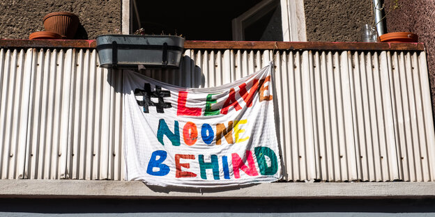 Transparent #LeaveNoOneBehind" hängt an einem Balkon