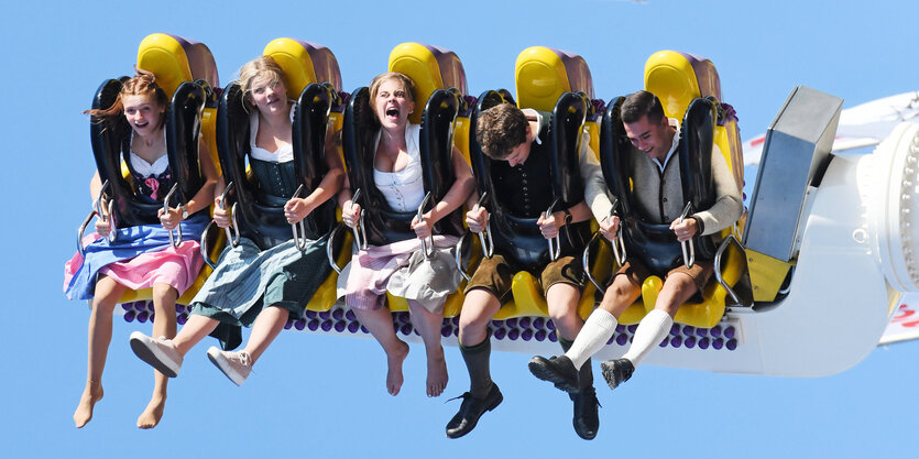 Menschen lachen in einem Fahrgeschäft.