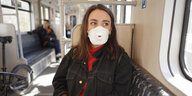 Eine Frau sitzt mit Mundschutz in der U-Bahnlinie U1