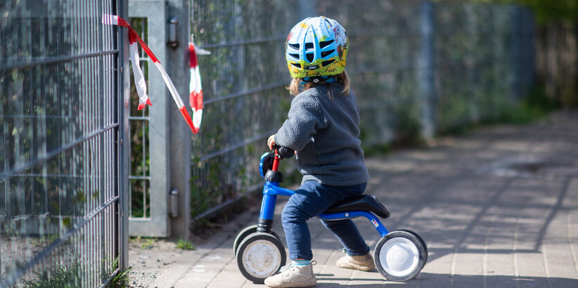 Kind vor geschlossenem Spielplatz