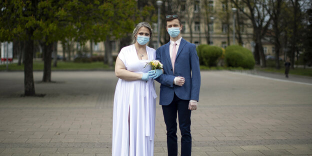 ein Brautpaar mit Mundschutz