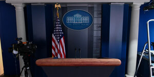 Leeres Rednerpult, dahinter eine US-Fahne und das Emblem des Weißen Hauses