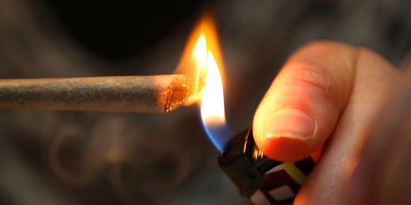 Ein Joint wird an ein Feuerzeug gehalten