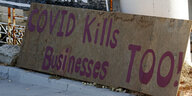auf einer Holzplatte steht "Covid kills business too!"