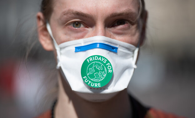 Ein Mensche trägt eine Nasen-Mund-Maske mit einen "Fridays for future"-Afkleber