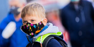 Ein Junge mit einer bunten Atemschutzmaske