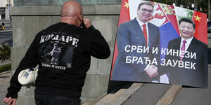Ein Mann und ein Plakat mit Serbiens Präsident Vucic und dem chinesischen Staatschef Xi Jinping, Aufschrift: "Serben und Chinesen für immer Brüder" in Belgrad