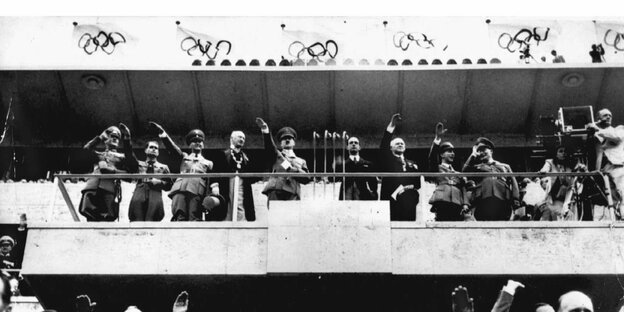 Schwarz-weiß Bild von Nazis, die auf einer Tribühne stehen und den Hitlergruß zeigen