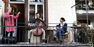 Drei Musiker auf einem Balkon