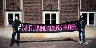 Zwei Männer halten ein Transparent mit der Aufschrift: shutdownlindenstraße