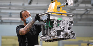 Ein Arbeiter montiert im Daimler Powertrain-Werk in Bad Cannstatt einen Motor