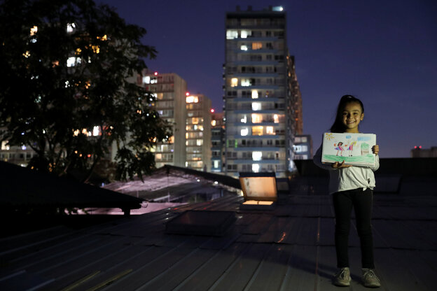 Ein Mädchen mit einem selbstgemalten Bild auf einem nächtlichen Dach.