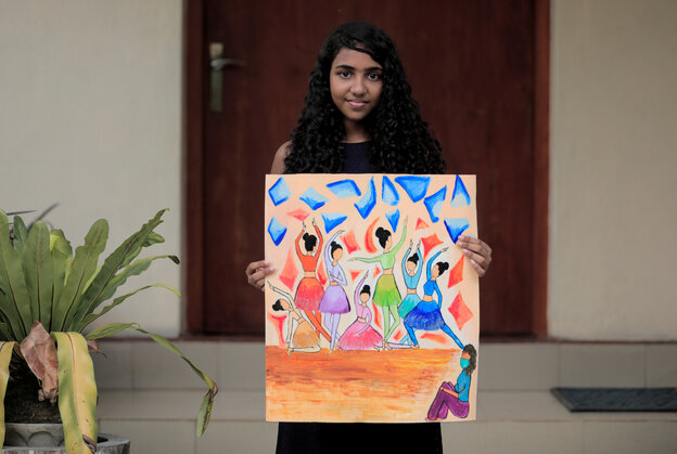 Ein Mädchen mit einem selbstgemalten Bild vor einer Wohnungstür.