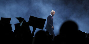 Joe Biden auf einer Bühne mit winkendem Publikum