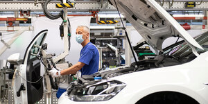 Ein Mitarbeiter in der VW-Produktion trägt einen Mundschutz