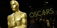 Eine überlebensgroße Oscar-Statue. Es ist ein gioldener Mann mit Armen, die er an die Brust gedrückt hält.