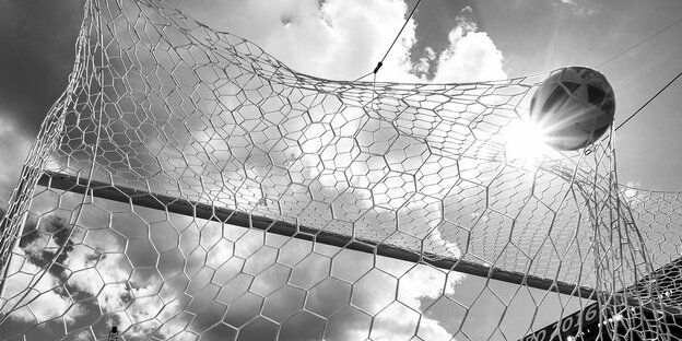 Ein Fußball fliegt in das Netz eines Tors