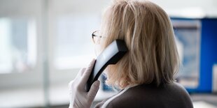 Eine Frau hält einen Telefonhörer in der Hand