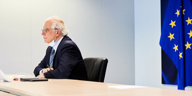 Josep Borrell sitzt vor einer Kamera, hinter ihm die EU-Flagge