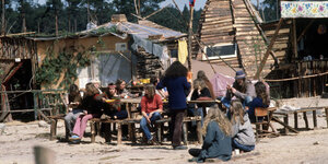 Um einen Tisch sitzen Bewohner des Anti-Atom-Dorfes im Wendland.