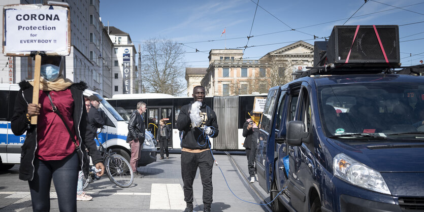 Eine Person trägt ein Schild mit der Aufschrift "Corona Protection for everybody"