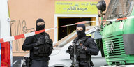 Polizisten in Schutzkleidung stehen vor einer Moschee