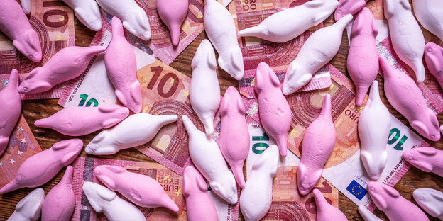 EIn Haufen essbare Schaummäuse in Pink und Weiß und darunter 10-Euro-Scheine