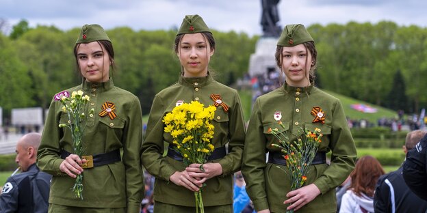 Mädchen der russischen Botschaftsschule in historischen Uniformen mit Blumen in der Hand am Sowjetischen Ehrenmal in Berlin-Treptow; ein Foto von 2019
