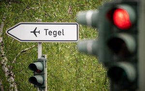 Ein Schild weist an einer Roten Ampel zum Flughafen Tegel – der Flughafen soll schließen Ein Schild weist an einer Roten Ampel zum Flughafen Tegel – der Flughafen soll schließen