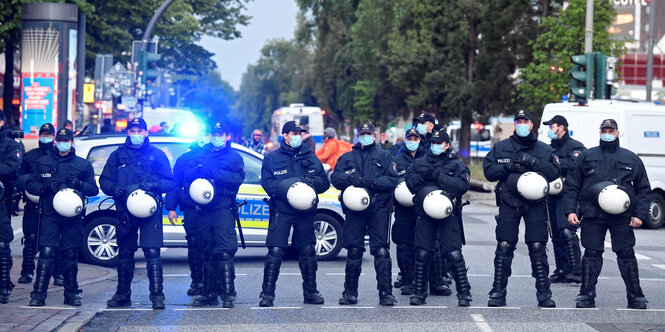 Eine Reihe Polizisten steht quer auf einer Straße