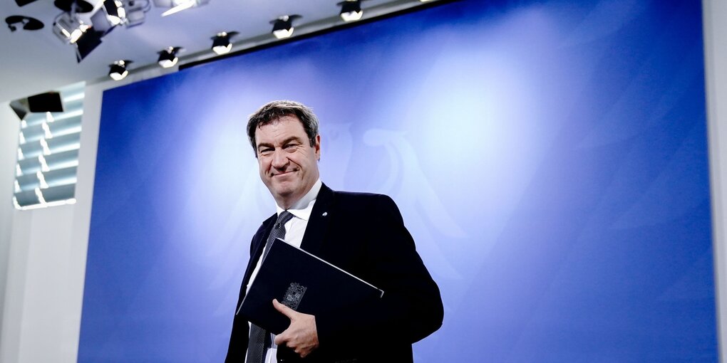 Markus Söder vor einer blauen WAnd