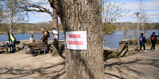 Menschen halten Abstand an einem See