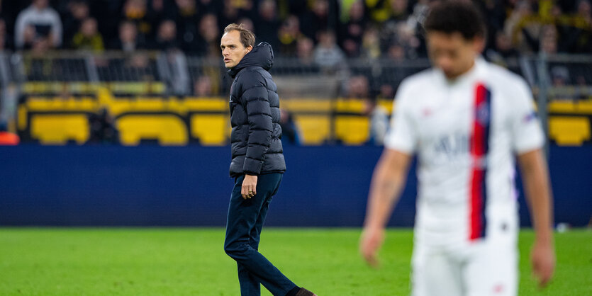 Ein Spieler und der Trainer Thomas Tuchele auf einem Fußballfeld