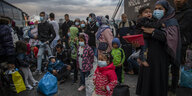 Flüchtlingsfamilien mit Gepäck vor einer Fähre