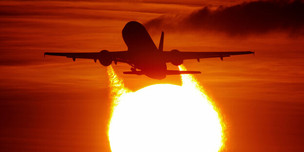 Ein Flugzeug startet in den Sonnenuntergang